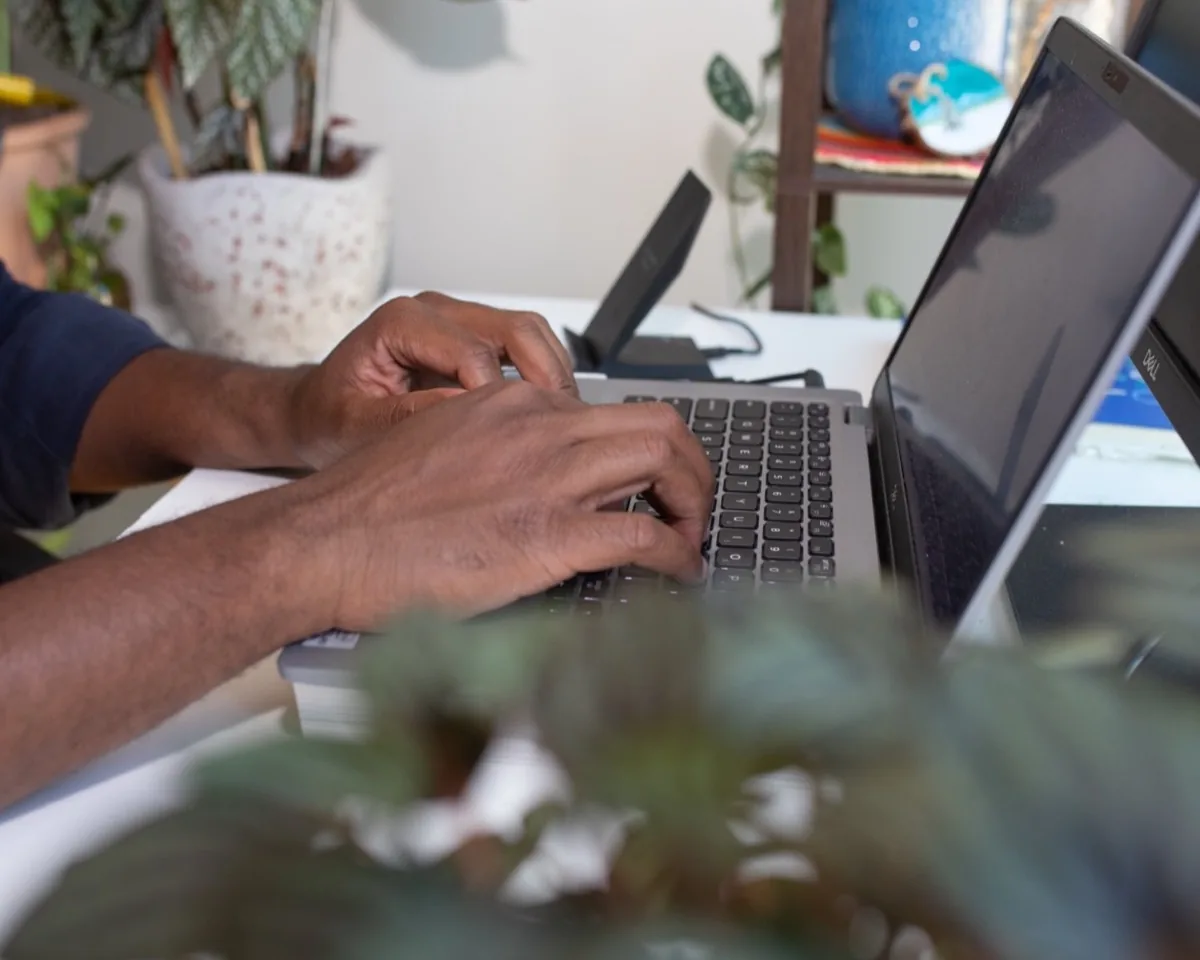 Mains sur le clavier d’un ordinateur portable, plan rapproché